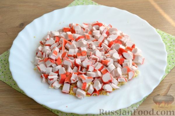 Слоёный салат с крабовыми палочками, красной рыбой, авокадо и сыром